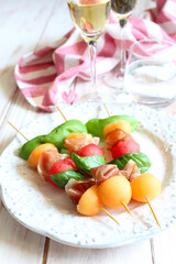 Healthy snack melon, watermelon, raw ham and basil on white background. Healthy food. Top view.
