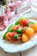 Healthy snack melon, watermelon, raw ham and basil on white background. Healthy food. Top view.