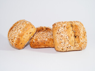 Baked bun soaked in sesame seeds and oatmeal isolated on white background.