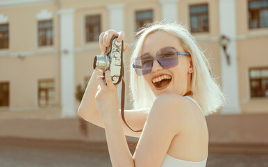 Young beauty woman blonde hair make photo on film camera, photographer