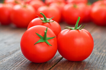 ripe red tomatoes on a wooden table.