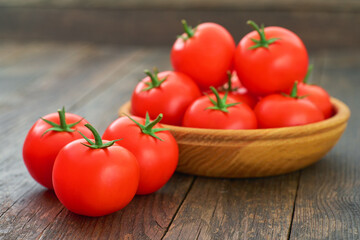 fresh red tomatoes in a wooden bowl on a table.