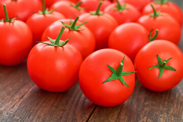 fresh red tomatoes on a wooden table, close up.