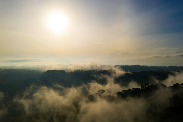 Obraz premium Aerial view, clouds above mountain top. Panoramic scene. High peak wonderful in morning sunrise. Shot from drone.