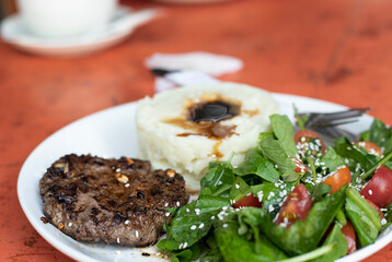 beef patty with mushed potato and salad 