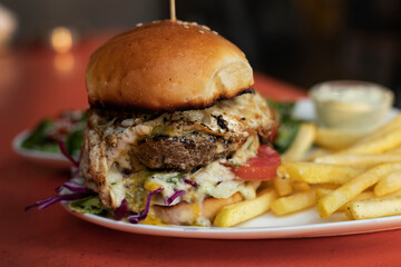 Juicy beef burger with egg and fries and salad