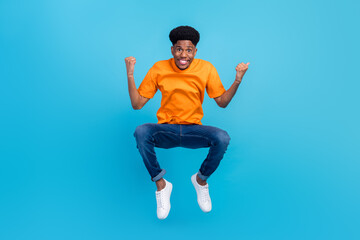 Full length body size view of attractive cool cheerful guy jumping rejoicing great success isolated over bright blue color background