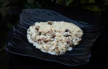 mushroom risotto on a black plate 