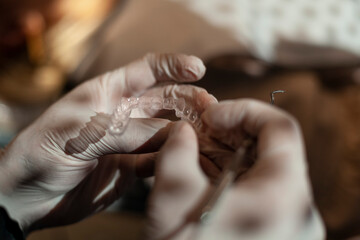 Orthodontist holds in his hands invisaling alienators, invisible orthodontic technique