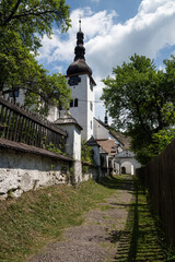 Narrow street leading to church in Spania Dolina, old mining village, Slovakia - obrazy, fototapety, plakaty