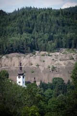 Fototapeta na wymiar Tower of Spania Dolina church surrounded by trees, Slovakia