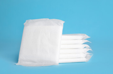 Stack of menstrual pads on light blue background