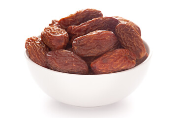 Close-up of dried date or chhuhara (Phoenix dactylifera) in a white ceramic bowl over white background.