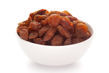 Close-up of dark brown munnakka raisins (dry grapes with seed )in a white ceramic bowl over white background.