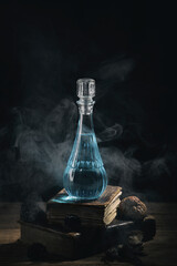 Obraz na płótnie Canvas Set of sorcery books and blue magic potion with smoke. Mana potion. Magic and wizardry concept.