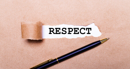 Torn kraft paper, white background with the text RESPECT. Nearby is a black handle. View from above