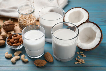Different nut milks on light blue wooden table