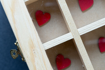 wooden hearts hand painted in red and a plain, untreated jewelry box - photographed from above in a...