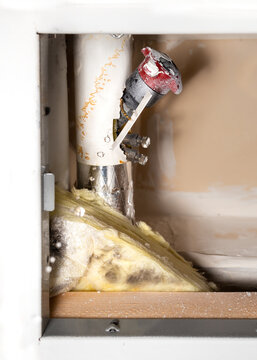 Dripping Water From A Pipe Next To A Water Shut-off Valve From A Ceiling Hatch In Building Corridor. Active Leak. Cause Is A Pinhole Leak In Copper Pipe. Selective Focus With Defocused Water Droplets.