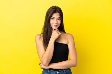 Obraz premium Young Brazilian woman isolated on yellow background thinking