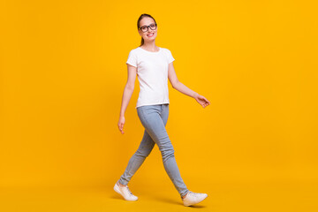 Fototapeta na wymiar Full length photo of young woman happy positive smile go walk step isolated over yellow color background