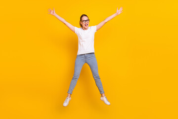 Fototapeta na wymiar Full body photo of happy charming young woman jump up raise hands isolated on yellow color background