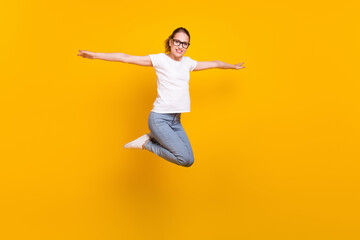 Fototapeta na wymiar Full size profile side photo of young cheerful woman happy positive smile jump up hands wings isolated over yellow color background