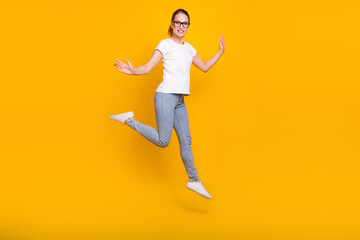 Fototapeta na wymiar Full length photo of young woman happy positive smile jump active isolated over yellow color background