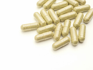 Flat lay of Andrographis paniculata capsules isolated on white background. Space for text. Herbal, medicine, and healthcare concept