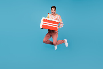 Full size photo of young man happy positive smile jump hold birthday cake slice tasty isolated over...