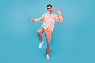 Fototapeta na wymiar Full body photo of positive happy funky man dance good mood wear sunglass isolated on pastel blue color background