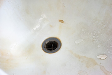 Very dirty bath tub close of shot with sink-hole
