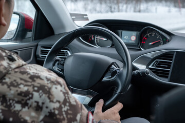 Man driving with holding steering wheel inside of modern car on the road