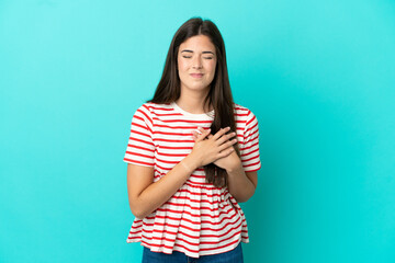 Young Brazilian woman isolated on blue background having a pain in the heart