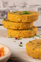 Raw veggie burger with chickpeas, vegetables and parsley leaves on kitchen countertop