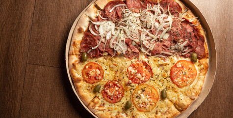 Pizza, pizza delivery inside the cardboard box used for delivery on a table, top view.