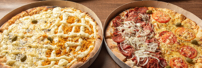 Pizza, two pizzas in Brazil inside cardboard boxes as they are delivered on a table, selective focus