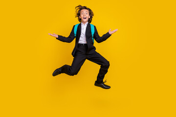 Fototapeta na wymiar Photo of sporty energetic small boy jump excited mood wear bag black uniform isolated yellow color background