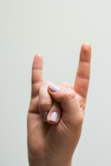 Hand making a rock symbol on a white background 