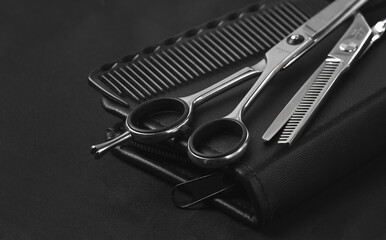 Professional barber tools, in the pocket, black stylist apron, horizontal, no people,