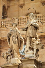 Baroque facade of the Cathedral of Murcia with sculptures of saints and angels with tower and bells...