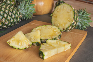Slices of pineapple on the wooden cutting board. Pineapple is a tropical fruit healthy and very juicy. They have sweet and sour taste. Pineapple is from South America now is the world famous fruit.