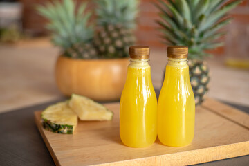 Bottle of of pineapple on the wooden cutting board. Pineapple is a tropical fruit healthy and very juicy. They have sweet and sour taste. Pineapple is from South America now is the world famous fruit.