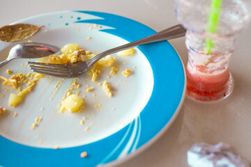 Empty plate with leftover food and empty glass of watermelon smoothie cocktail. Nutritious Hearty Colorie Lunch.