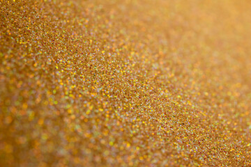 Full frame macro abstract of sparkling champagne color glitter surface background with bokeh and copy space