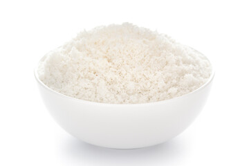 Close-up of white dry  desiccated organic coconut in a white ceramic bowl over white background.