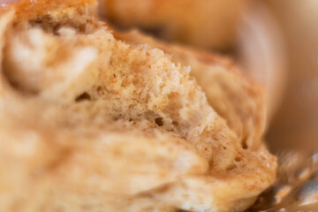 Fiber closeup of homemade fluffy bread hot out of the oven. Freshly baked buns made from whole wheat flour, gluten free.
Textures on a piece of fresh challah bun, air pockets and crust.
