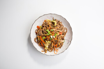 Soba noodles with beef, carrots, onions and sweet peppers isolated on white background
