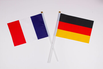Flag of France and flag of Germany crossed with each other on a white background. Isolated. The image illustrates the relationship between countries. Photo for news and articles on the media
