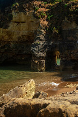 Orange cliffs and aquamarine water, beach with an arch